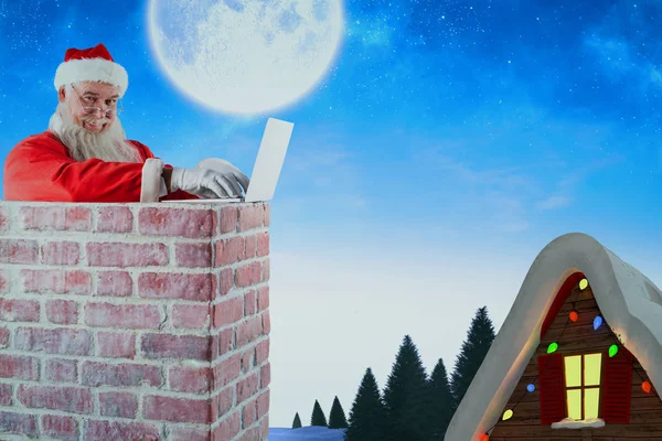 Santa claus met behulp van laptop — Stockfoto