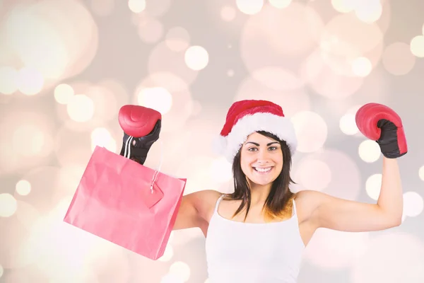 Brunette in boxing gloves holding shopping bags — Stock Photo, Image