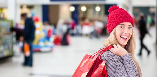 Festive blonde holding shopping bags — Stock Photo, Image