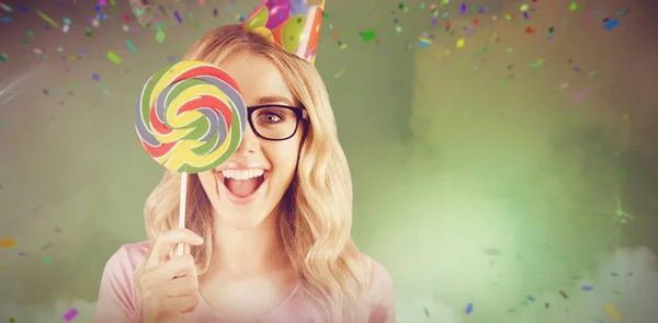 Composite image of portrait of a hipster hiding herself behind a lollipop — Stock Photo, Image