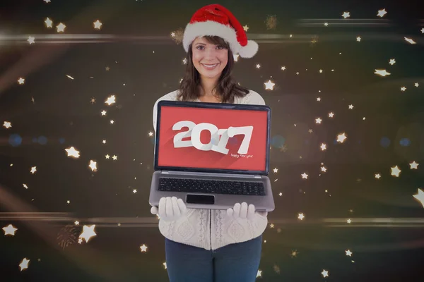 Brünette mit Weihnachtsmütze zeigt Laptop — Stockfoto