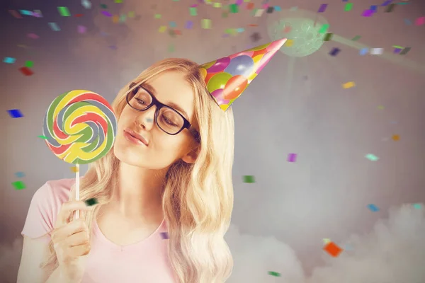 Sammansatt bild av en vacker hipster som innehar en giant lollipop — Stockfoto