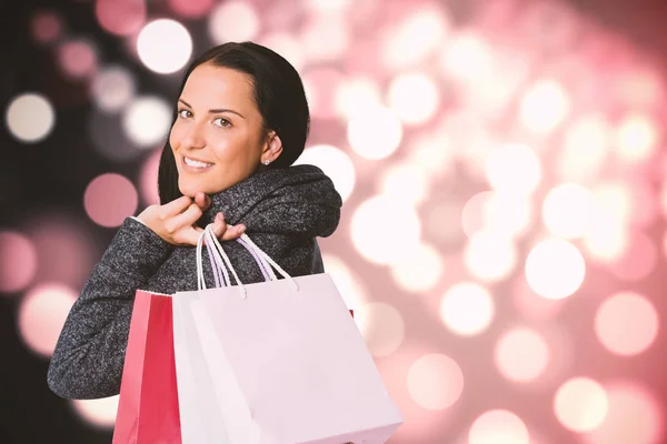 Imagem composta de mulher sorridente segurando saco de compras — Fotografia de Stock