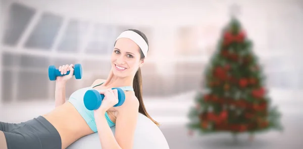 Žena cvičení s činkami na fitness míč — Stock fotografie