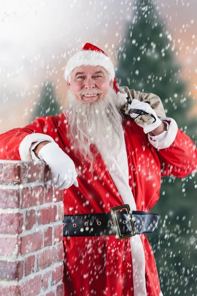 Santa claus nesoucí pytel plný dárků — Stock fotografie