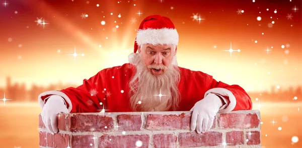 Weihnachtsmann lugt über Mauer — Stockfoto