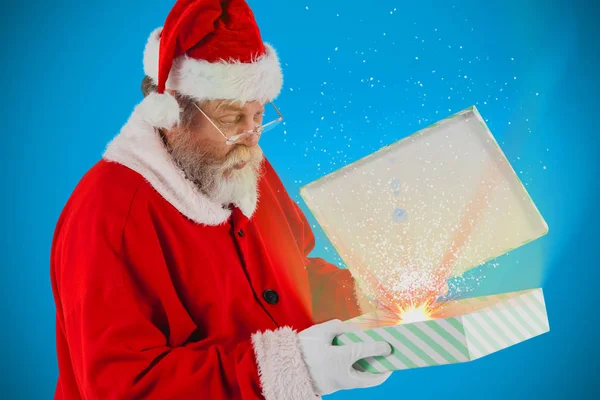 Санта Клаус смотрит на открытую подарочную коробку — стоковое фото