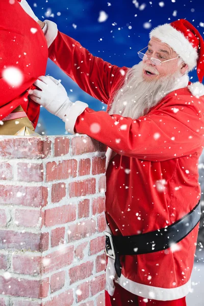 Santa claus umístění dárek do komína — Stock fotografie