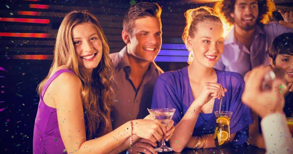 Друзья выпивают коктейль в баре — стоковое фото