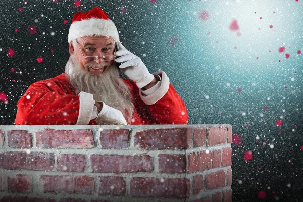 Santa Claus står bredvid skorsten — Stockfoto