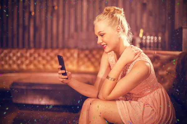 Femme assise sur le canapé et utilisant le téléphone — Photo