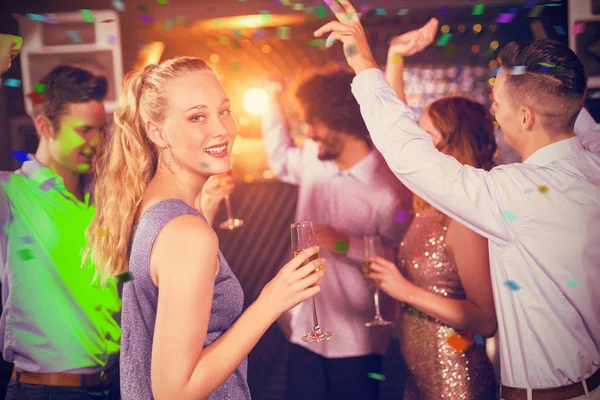 Mujer sosteniendo copa de champán mientras baila — Foto de Stock