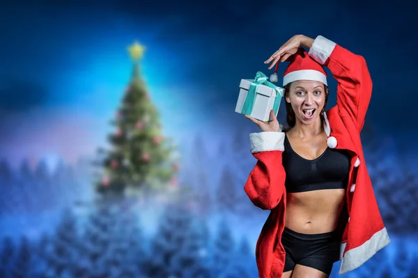 Cheerful athlete holding Christmas gift — Stock Photo, Image