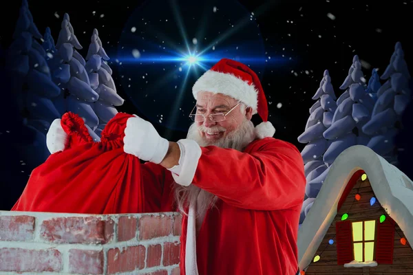 Santa claus plaatsen kerst tas in de schoorsteen — Stockfoto