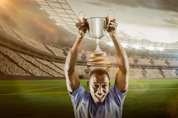 Athlete cheering while holding trophy — Stock Photo, Image