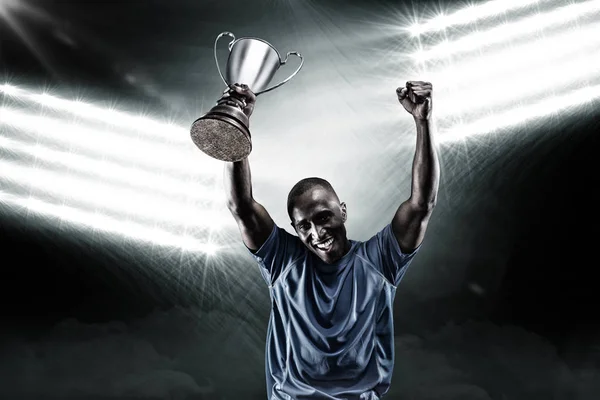 Sportsman cheering while holding trophy — Stock Photo, Image