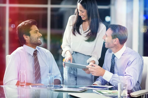 Empresária discutindo com colegas sobre tablet — Fotografia de Stock