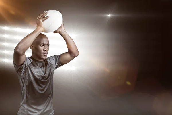 Selbstbewusster Sportler wirft Rugbyball — Stockfoto