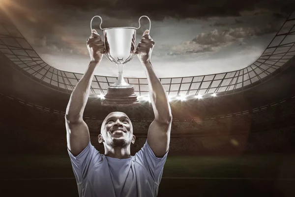 Sportsman looking up while holding trophy — Stock Photo, Image