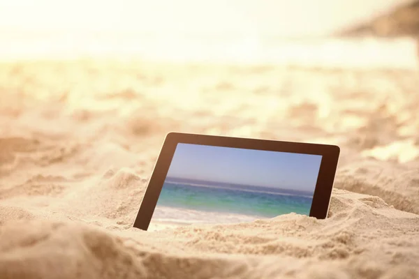 Tavoletta digitale tenuta su sabbia a spiaggia — Foto Stock