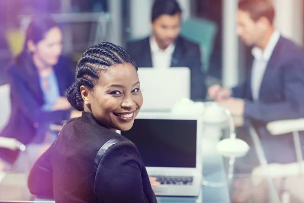 Affärskvinna leende medan du sitter av kollegor — Stockfoto