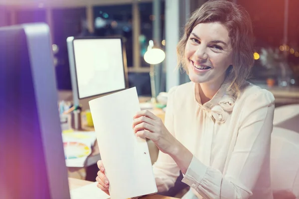 Portrait of businesswoman holding document at desk — Stock Photo, Image