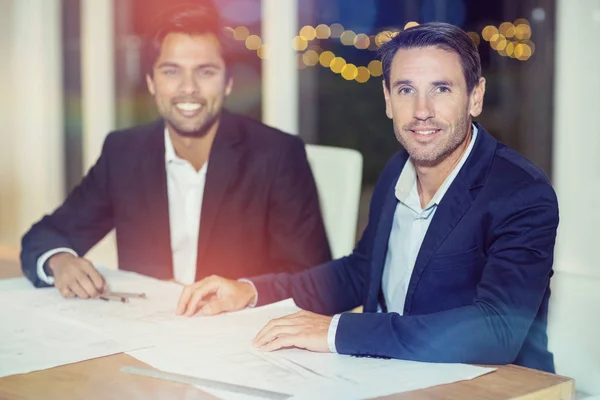 Hommes d'affaires assis à leur bureau — Photo