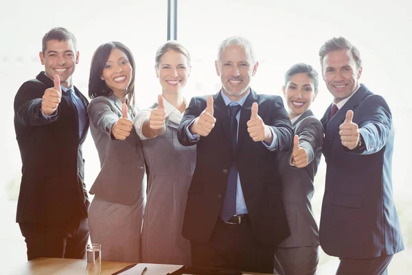 Empresários de pé juntos e dando polegares para cima — Fotografia de Stock