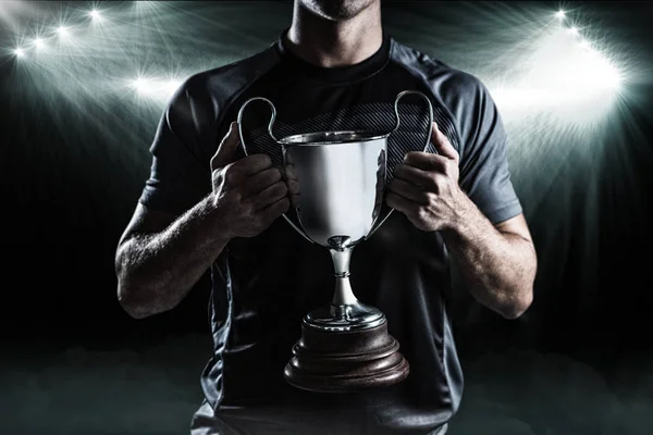 Victorious rugby player holding trophy — Stock Photo, Image