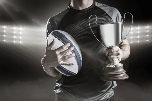 Jogador de rugby bem sucedido segurando troféu — Fotografia de Stock