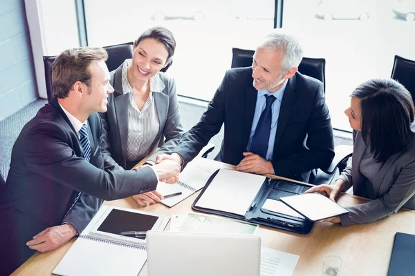 Affärsmän skakar hand i konferensrummet — Stockfoto