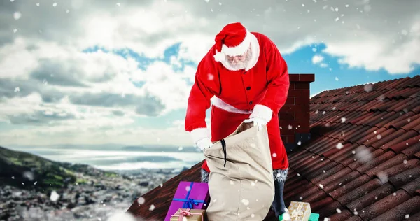 Papai Noel enchendo caixas de presente no saco — Fotografia de Stock