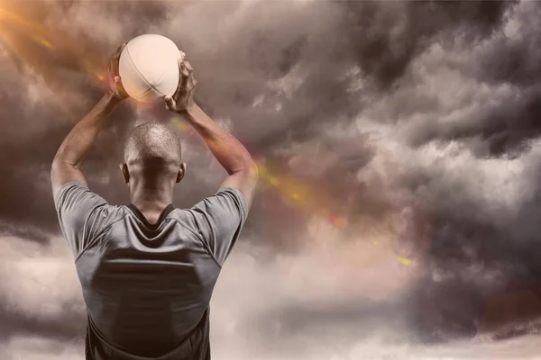 Композитне зображення спортсмена, що кидає м'яч регбі 3D — стокове фото