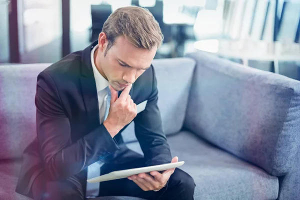 Thoughtful businessman looking at digital tablet — Stock Photo, Image