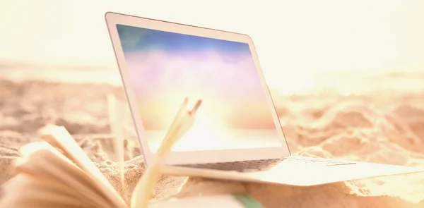 Відкрити книгу і ноутбук на піску — стокове фото