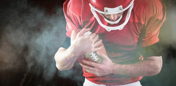 Jogador de futebol americano protegendo o futebol a — Fotografia de Stock