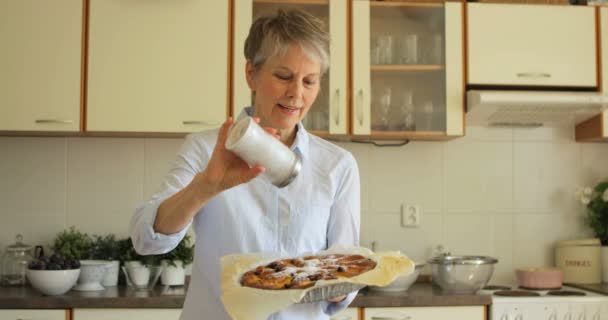 Frau bestreut gebackene Torte mit Zucker — Stockvideo
