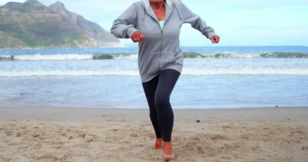 Senior Kvinna jogga på stranden — Stockvideo