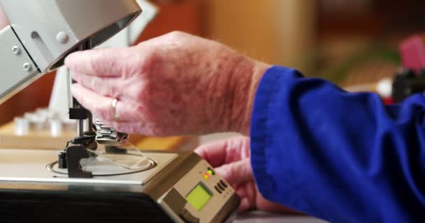 Uhrmacher stellt Uhr auf Maschine — Stockvideo