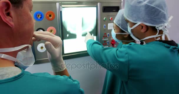 Хирурги и медсестра смотрят на рентген — стоковое видео