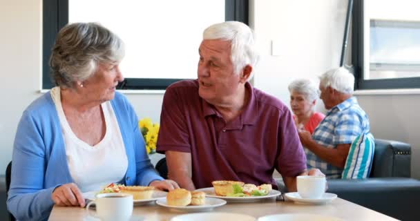 Старша пара взаємодіє один з одним під час сніданку — стокове відео