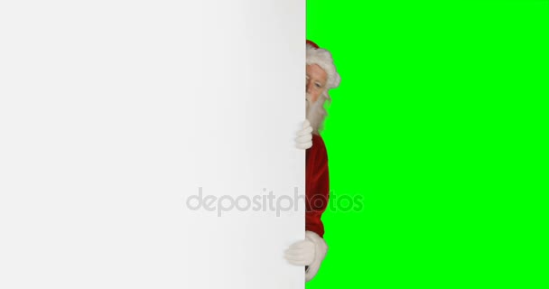 Удивлённый Санта Клаус прячется за белым экраном — стоковое видео