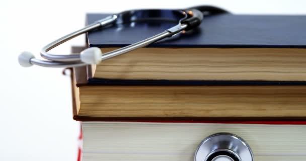 Stethoscope with stack of books — Stock Video