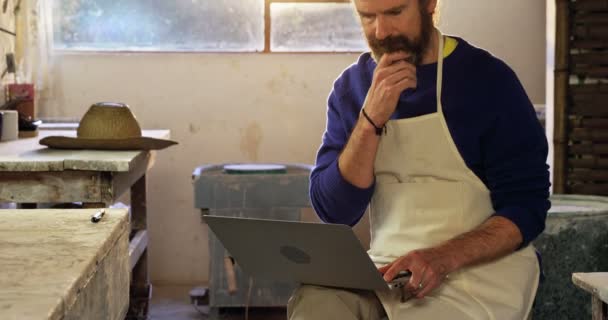 Mannelijke potter met behulp van laptop — Stockvideo