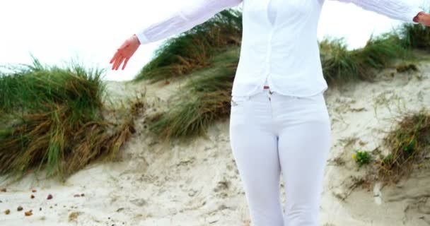 Mogen kvinna med armarna utsträckta på stranden — Stockvideo