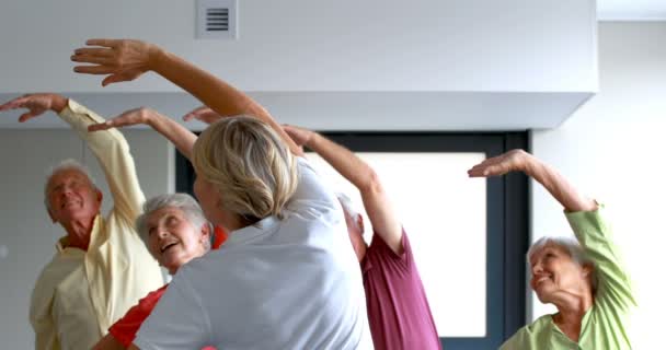 Trainer assisting senior citizens in exercising — Stock Video