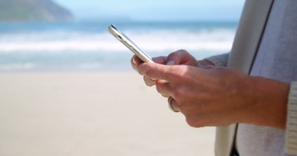 女性のビーチでの電話の使用 — ストック動画