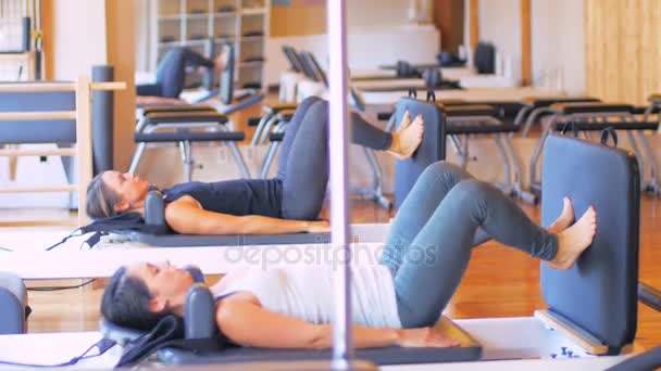 Las mujeres haciendo ejercicio en el equipo de gimnasio — Vídeo de stock