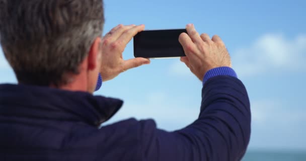 成熟した男の携帯電話からの眺めの写真を撮る — ストック動画