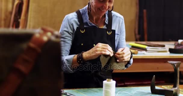 Craftswoman bezig met een stukje leer — Stockvideo